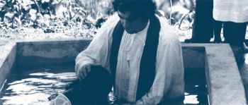 Fr. Frank Hoare baptizing by immersion, 1976